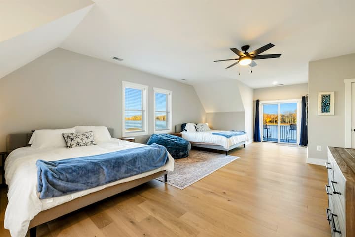 Una camera da letto spaziosa e luminosa con più letti, un balcone privato, un bagno interno e un'accogliente zona salotto, perfetta per ospitare famiglie o gruppi.