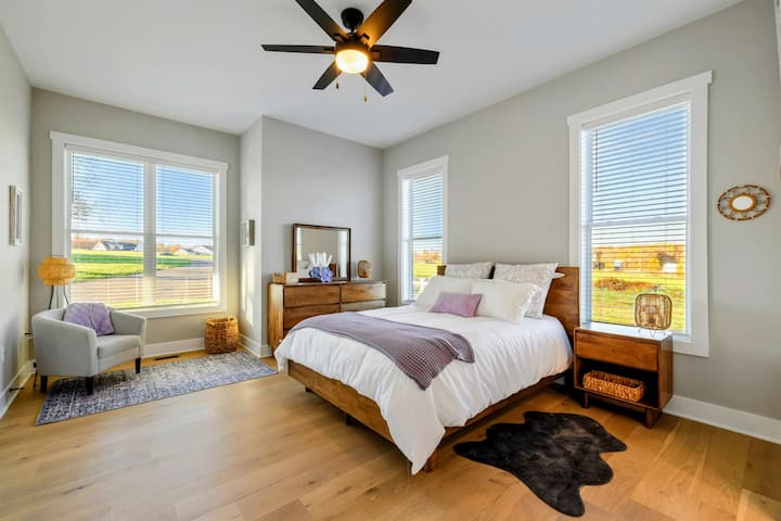 Una camera da letto tranquilla con luce naturale, un letto accogliente, pavimenti in legno massello e un bagno in comune con jack e jill per il massimo comfort.