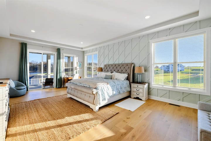 Una lussuosa e spaziosa camera da letto principale con arredi eleganti, abbondante luce naturale, balcone privato e bagno interno.