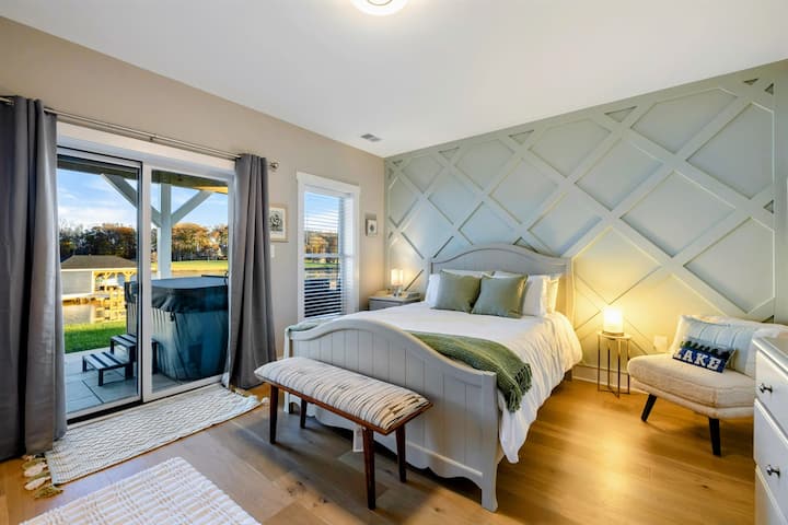 Un'accogliente camera da letto con un'incantevole parete decorativa, arredi eleganti, accesso al patio, vista serena e bagno Jack e Jill con doccia walk-in.