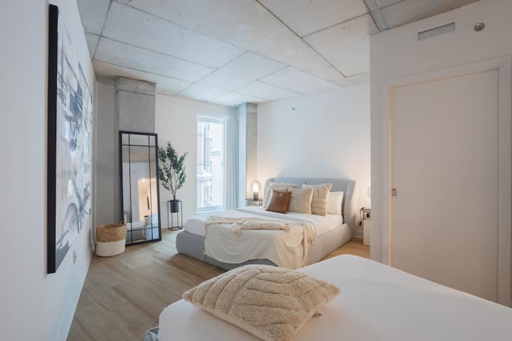 Rifugiati in questa tranquilla camera da letto, incorniciata da un elegante soffitto industriale e da morbide lenzuola che promettono notti riposanti