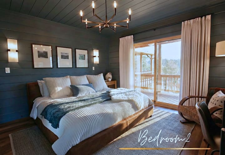 Bedroom 2 – A cozy retreat with a plush king bed, warm modern décor, and private deck access for taking in the views.