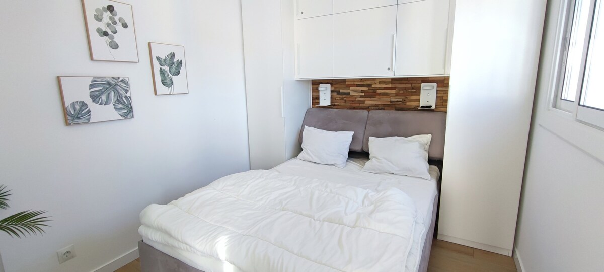 Დიდი ოთახი ორადგილიანი საწოლით, თავზე ლამპებითა და დამტენებით.  Გარდერობები საკიდებით უკეთესი ორგანიზებისთვის. 