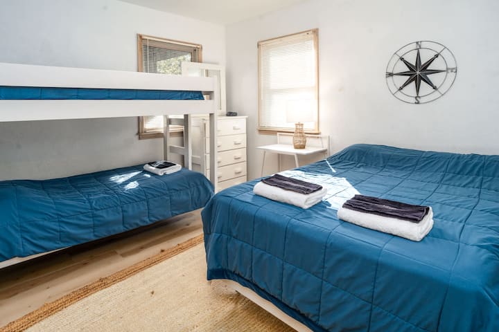 Dormitorio de nivel medio con dos literas y una cama doble