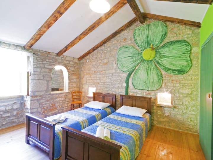 O quarto colorido com duas camas de solteiro irradia charme vibrante e conforto aconchegante.