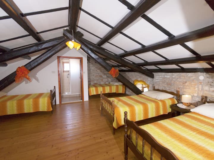 Este amplo quarto com várias camas de solteiro é ideal para acomodar grandes grupos.