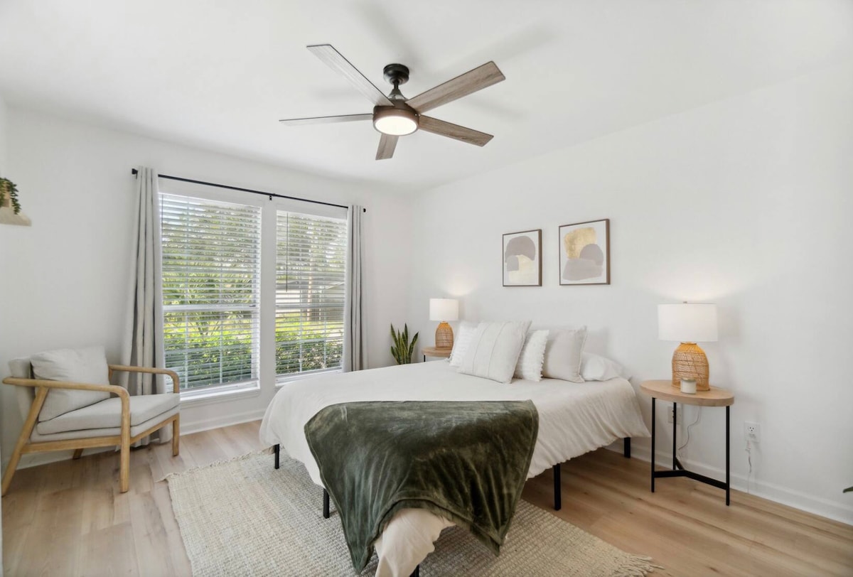 Lichte en luchtige slaapkamer aan de voorkant van het huis met een comfortabel queensize bed en een zitstoel om in te ontspannen.