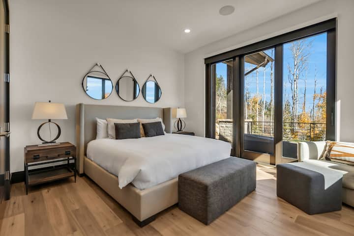 睡房配有一張床、床頭櫃、燈和通往陽台的滑動門