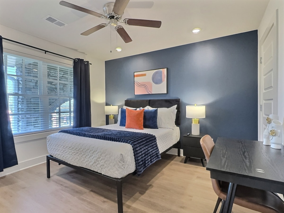 Het stijlvolle bed, versierd met zachte kussens en een gezellige deken, nodigt je uit om te ontspannen na een lange dag