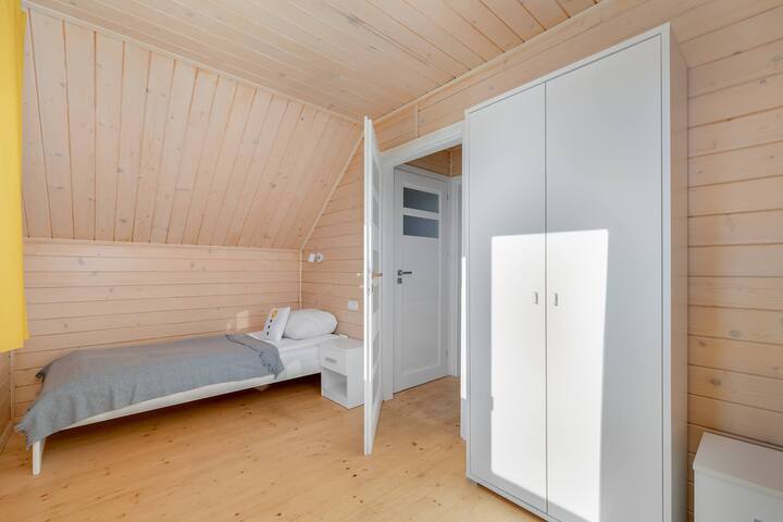 Udobna spavaća soba s krevetom za jednu osobu.