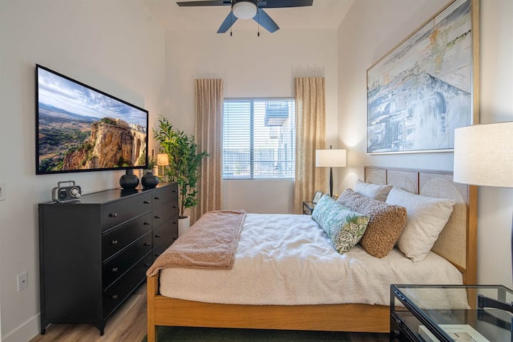 Cama tamaño queen. Un dormitorio tranquilo diseñado para la relajación, con una cama lujosa y colores relajantes.