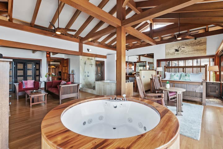The spacious primary suite blends traditional Japanese craftsmanship with modern comfort, featuring handcrafted timber beams, a private sitting area, and a signature ocean-view soaking tub.