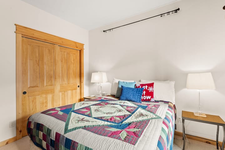 La chambre d'hôtes de niveau inférieur dispose d'un lit queen size, d'une télévision et d'un accès au patio. 