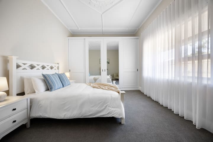 柔和的光线透过薄纱窗帘，突出了房间的优雅比例和精致天花板。