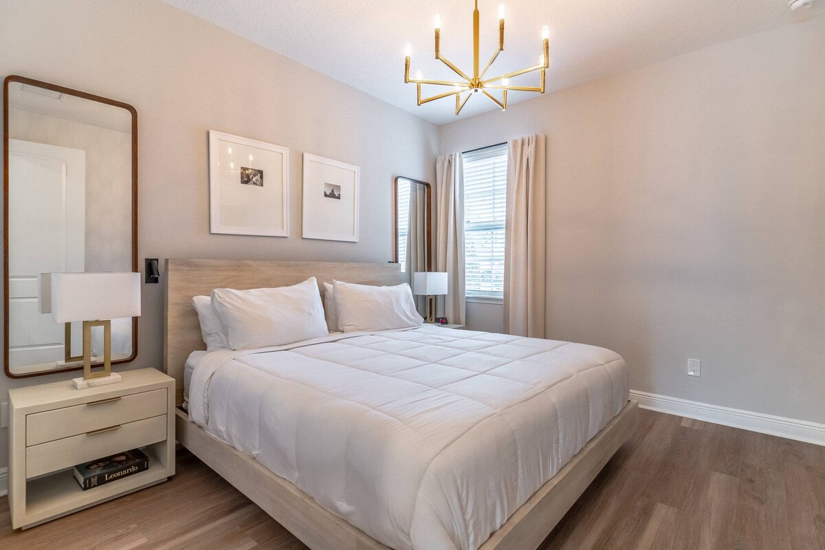 غرفة نوم بسرير كينج في الطابق السفلي مع تلفزيون وخزانة