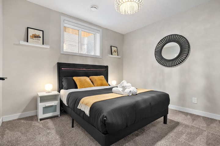 Štýlová hosťovská spálňa s plyšovou čiernou posteľou a teplým zlatým zariadením