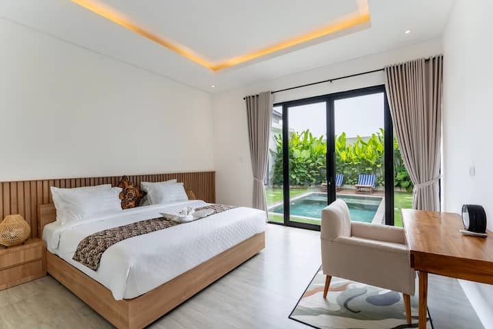 Svetlá spálňa s manželskou posteľou, sklenenými dverami a prirodzeným svetlom z každého rohu.