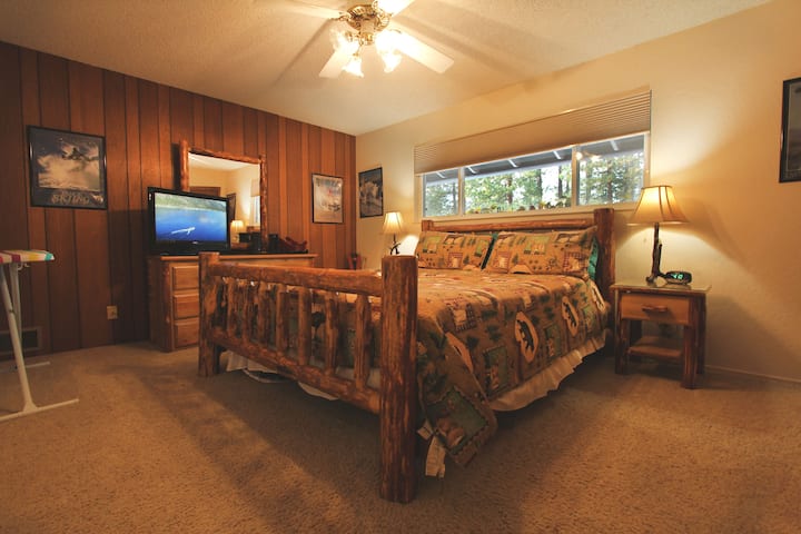 Open the blinds to the pines from the king bed.