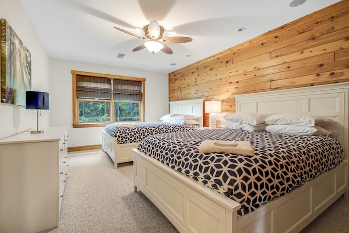 ห้องนอนคู่พร้อมหน้าต่างพาโนรามาและฉากหลังป่าที่เงียบสงบ