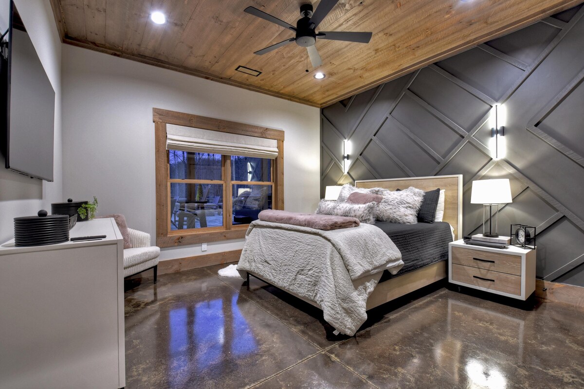 Изискана спалня с модерна дървена ламперия и уютно легло.