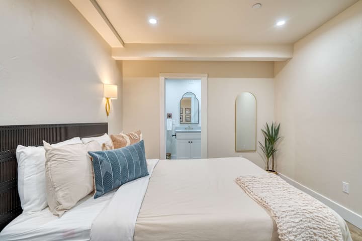 Bedroom with a bed beside the bathroom doorway.