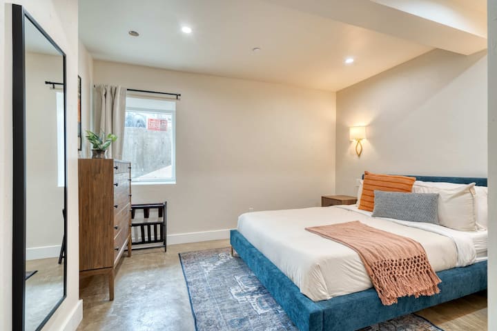 Bedroom with an upholstered bed and mirrored closet doors.
