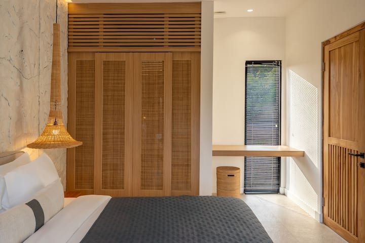 Просторен распоред со природни текстури и панели за гардероба од бамбус.