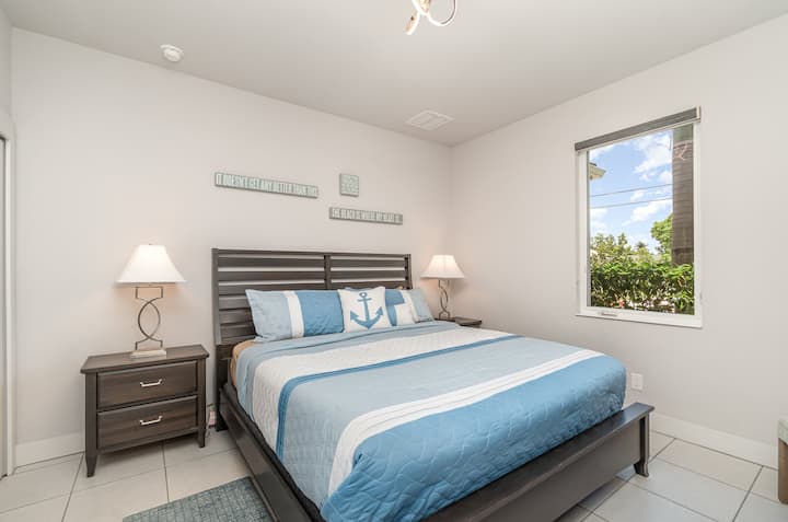 Dormitorio fresco y tranquilo con decoración de temática náutica y una vista serena de la vegetación.