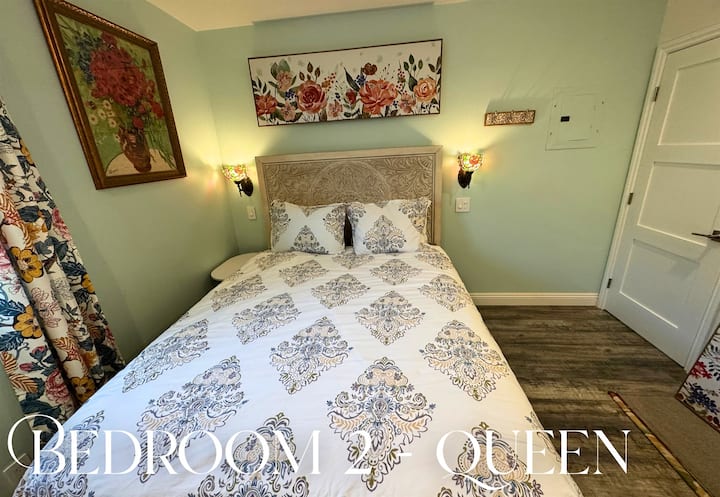 נוחות של מיטת קווין סייז, פרטי פרחים ואור טבעי לאווירה נינוחה ועליזה.