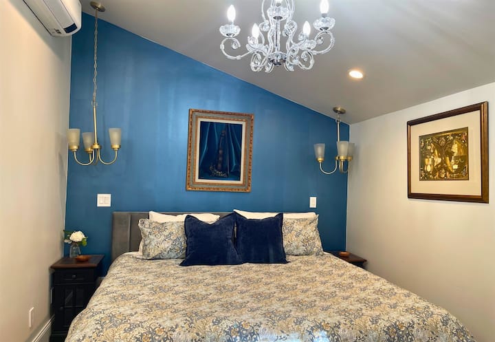 בחדר השינה הזה יש גם גווני כחול כהה אלגנטיים, נברשת ומיטת קינג סייז מפוארת לשינה נינוחה.