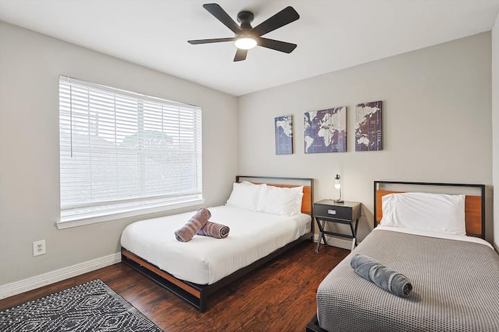 Útulná spálňa na druhom poschodí s manželskou posteľou, samostatnými lôžkami a stropným ventilátorom.