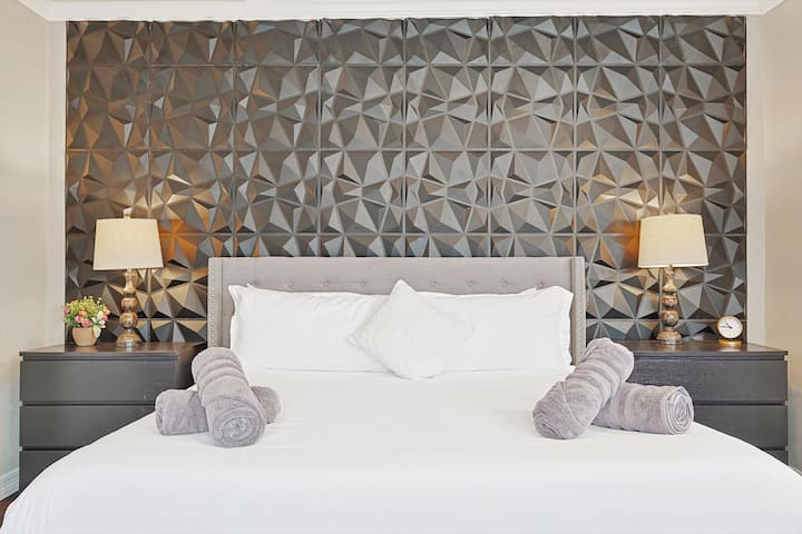 Primárna spálňa na prvom poschodí s televízorom a posedením.