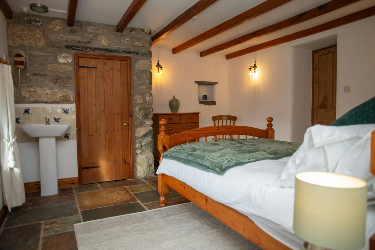 Spálňa s manželskou posteľou, umývadlom na ruky a zásuvkami