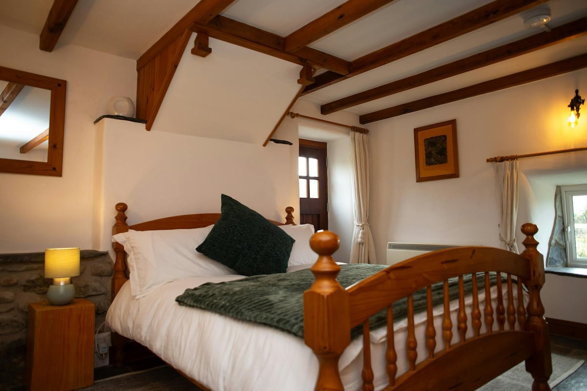 Spálňa s manželskou posteľou, nočným stolíkom a lampou