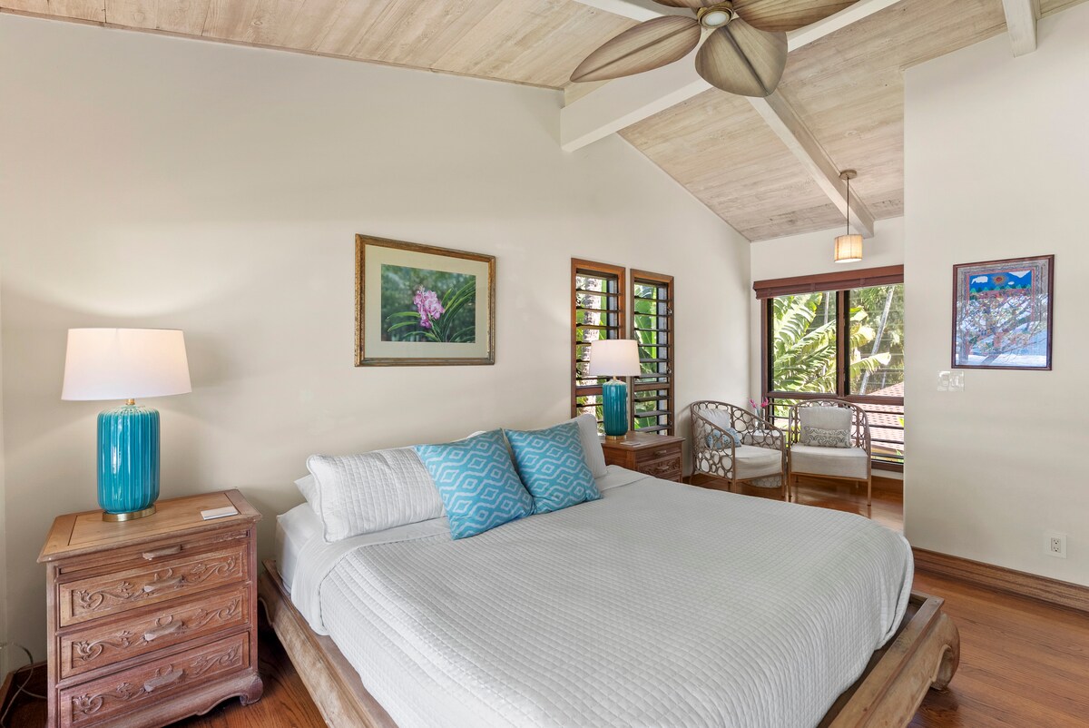Relax in this serene bedroom with a king-size bed, vaulted ceilings, and tropical views.