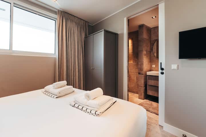 ห้องนอนที่อบอุ่นและต้อนรับดี มีแสงธรรมชาติที่นุ่มนวล ผ้าปูที่นอนที่สดชื่น และห้องน้ำส่วนตัวของคุณเองอยู่ห่างออกไปเพียงไม่กี่ก้าว ความสะดวกสบายอย่างเรียบง่าย