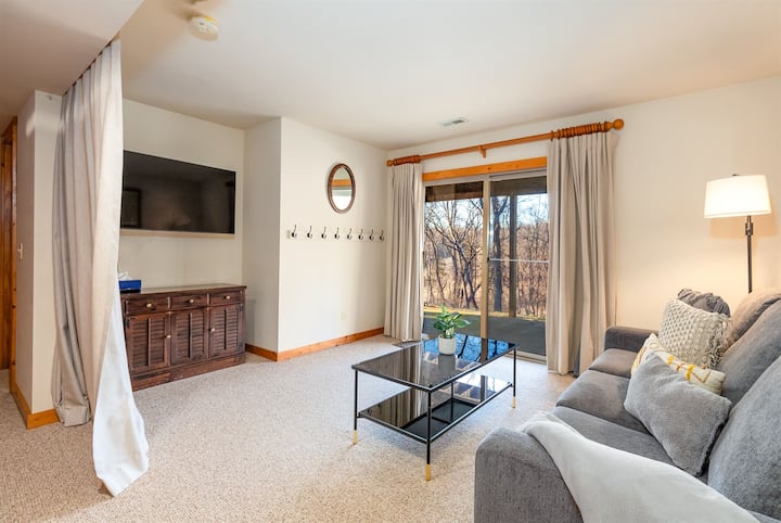 Дневна соба на пониско ниво со кауч за спиење и завеса за затворање на просторот