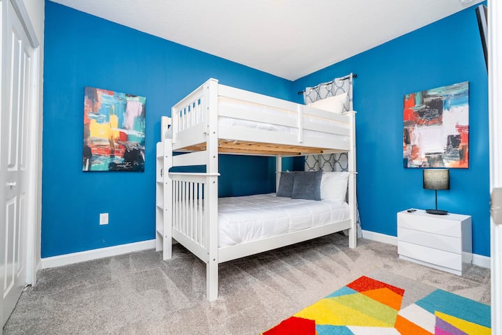 [2nd Floor]  Bold Colors, Fun Feels – Letti a castello in una stanza vivace piena di energia e arte moderna. 