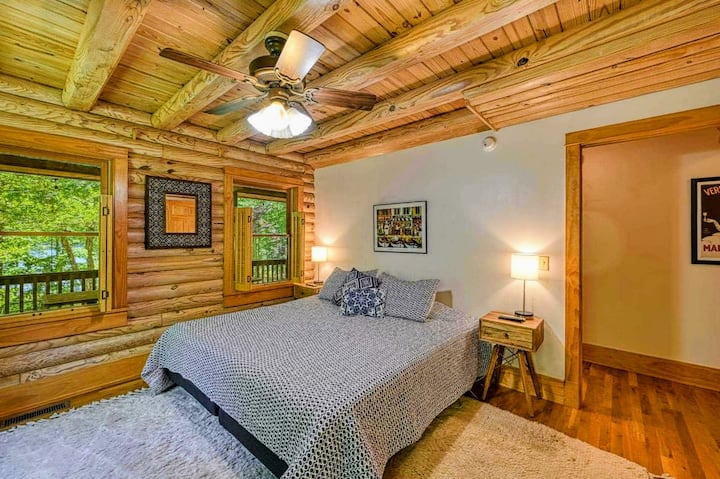 Relájate en este acogedor dormitorio estilo cabaña de madera con hermosas vistas naturales y muebles cómodos para una noche de sueño tranquilo.