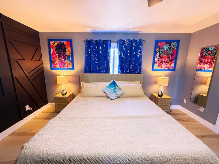 Удобна спална соба исполнета со уметнички шарм. Завесите и топлото осветлување создаваат релаксирачки амбиент. Совршен спој на удобност и креативност за мирен престој.