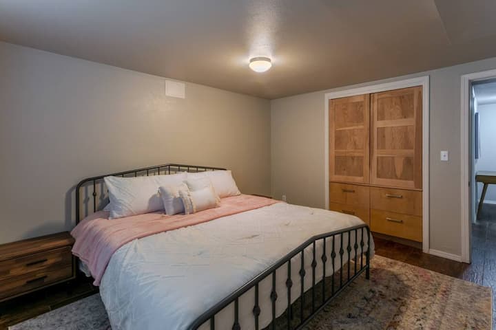 Spavaća soba u suterenu s velikim bračnim krevetom i velikim ormarima 