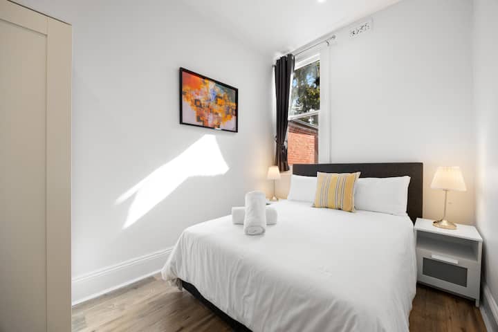 La lumière du soleil filtre, illumine la pièce et met en évidence la literie blanche impeccable.