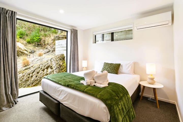 Dhomë gjumi e rehatshme "king" me pamje nga muri shkëmbor dhe ndriçim të butë