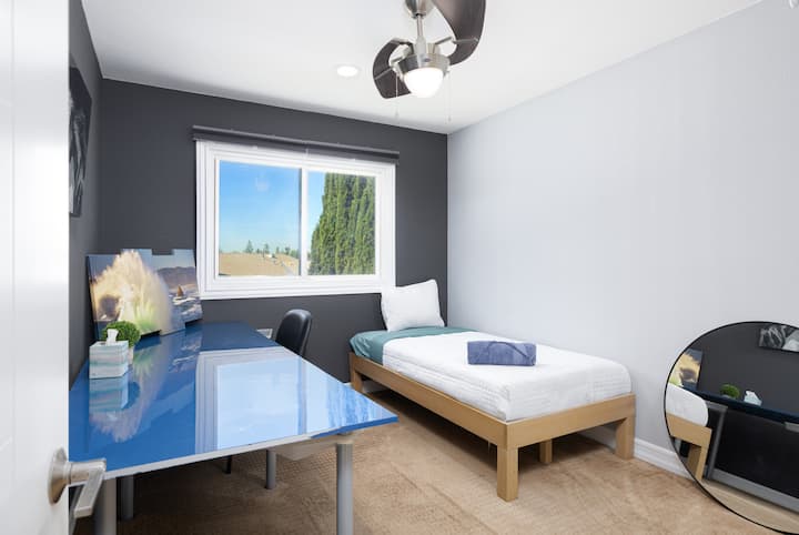 Трета спална соба опремена со двоен кревет, биро и плакар.