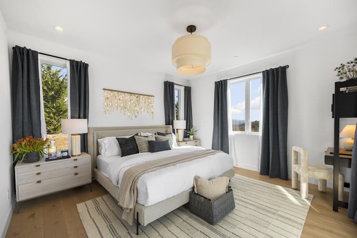 Disfruta de la suite del dormitorio principal con una cama tamaño king ultracómoda, escritorio y puertas correderas del piso al techo de LaCantina que se abren a la terraza Vista.