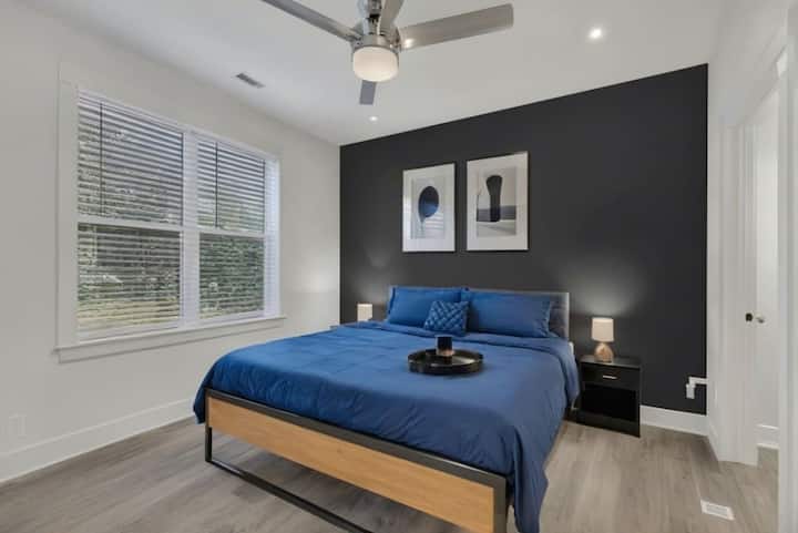 Ett elegant och mysigt sovrum med en king size-säng, modern inredning och en djärv accentvägg. Njut av en lugn natts sömn med mjuk belysning, eleganta möbler och gott om naturligt ljus.