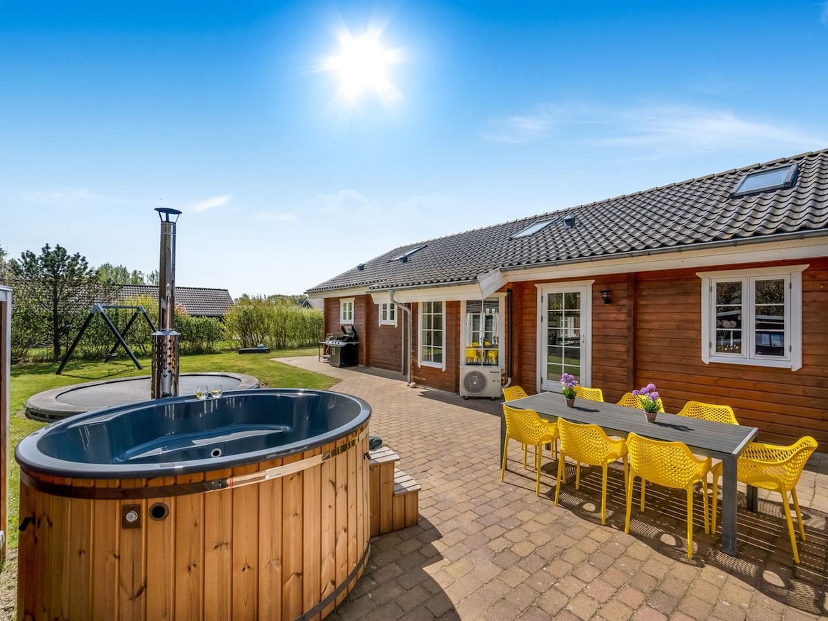 An outdoor area is highlighted by a hot tub and a dining set with bright yellow chairs. Sunlight shines down, creating a vibrant atmosphere. A swing set and a grill are visible in the garden, alongside a well-maintained patio space.