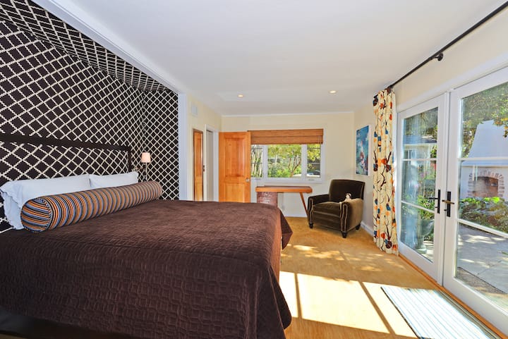 Odvážna spálňa pre hostí s vlastnou tapetou, stolom a prístupom na súkromnú terasu