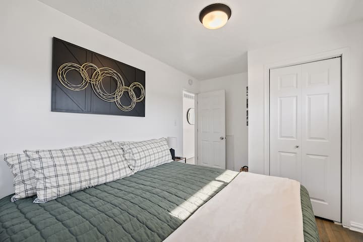 غرفة نوم بسرير كينج وخزانة وتلفزيون ذكي وطاولتان جانبيتان ومصباحان