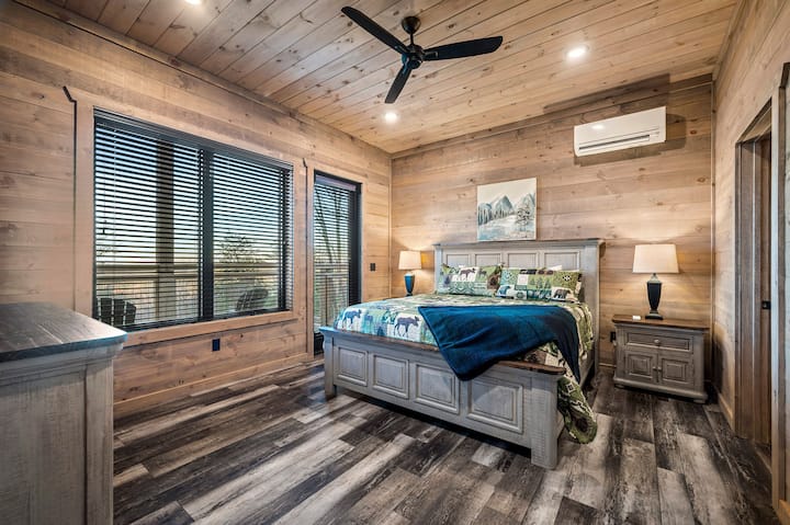 Спална соба која го одзема здивот и прозорци од подот до таванот кои пропуштаат природна светлина и обезбедуваат пристап до приватен балкон. Удобниот кревет и богатите дрвени акценти создаваат спокојно планинско одморалиште.